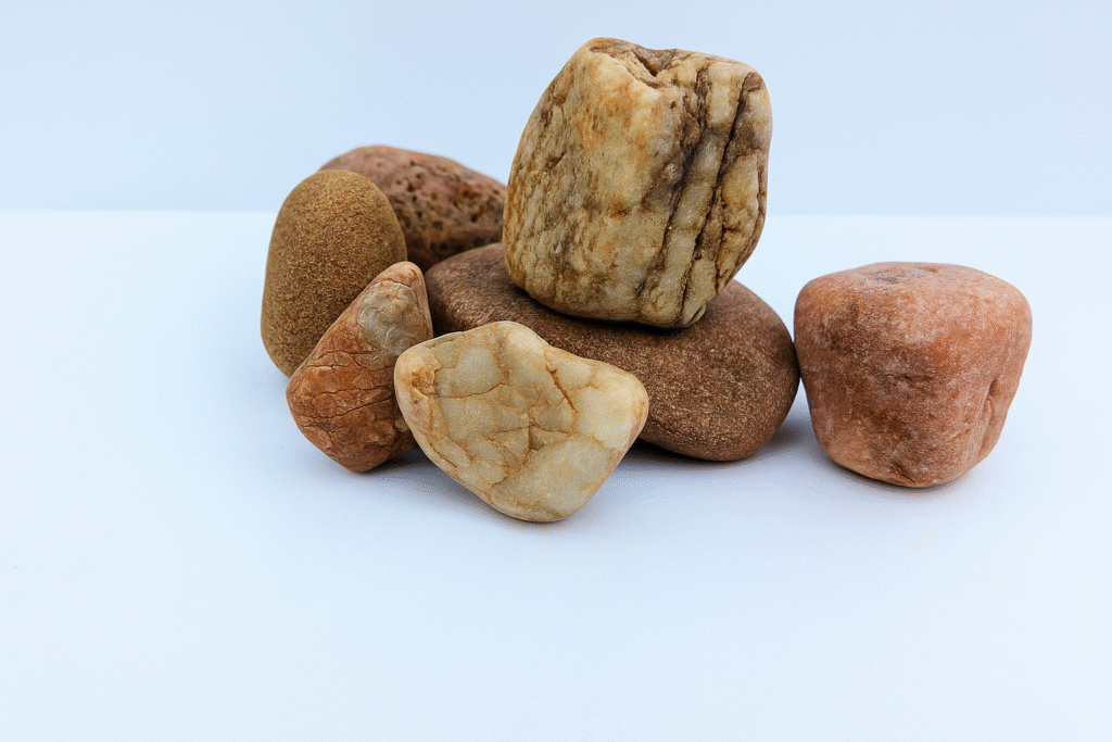 Pedras naturais empilhadas sobre fundo branco, simbolizando cálculo renal
